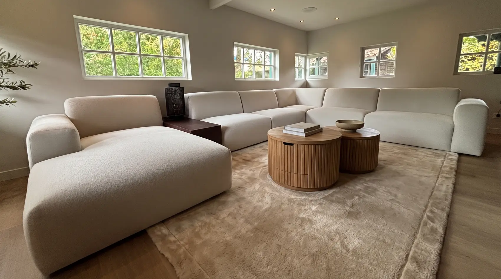 Modulares Ecksofa Vendi mit rundem Teak-Couchtisch Bailar und Teppich Sophisticate von Rivièra Maison