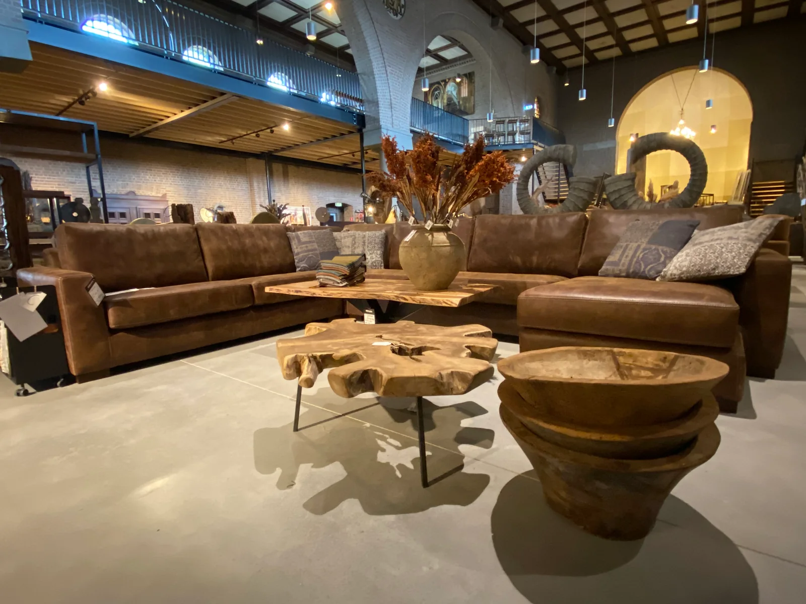 Ledersofa und Holztische in der Mokana Möbelkirche